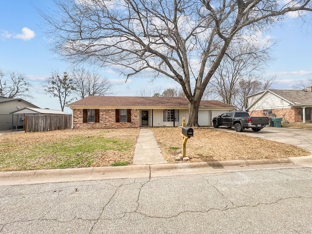 view of front facade with brick siding, an attached garage, and driveway