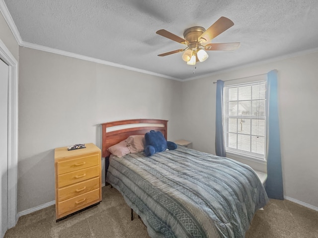 bedroom with carpet flooring, a textured ceiling, a ceiling fan, and ornamental molding