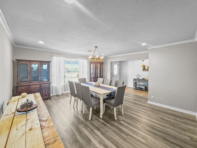 dining space featuring baseboards, wood finished floors, and crown molding