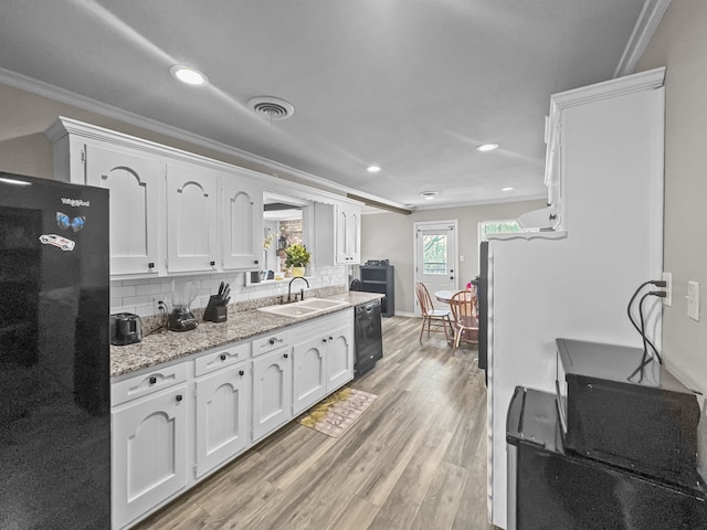 kitchen with visible vents, ornamental molding, a sink, black appliances, and white cabinets