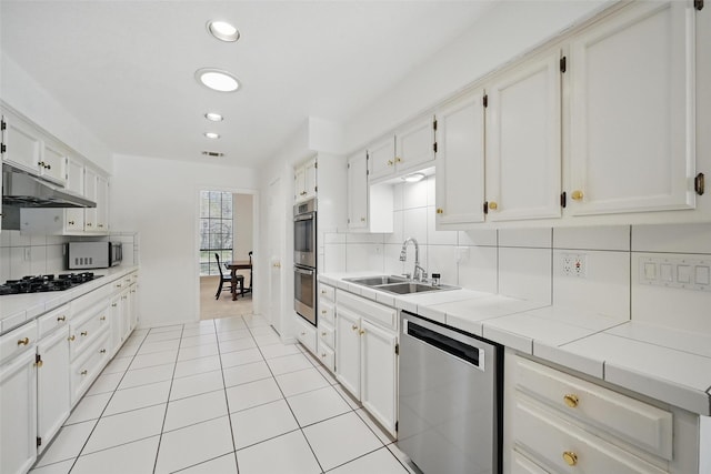 3620 Red Oak Dr, Corinth, TX 76208 - kitchen with appliances with stainless steel finishes, a sink, under cabinet range hood, decorative backsplash, and white cabinetry