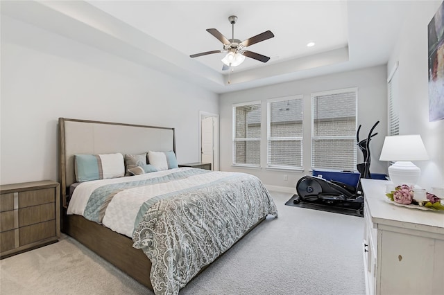 bedroom featuring baseboards, a raised ceiling, light colored carpet, ceiling fan, and recessed lighting