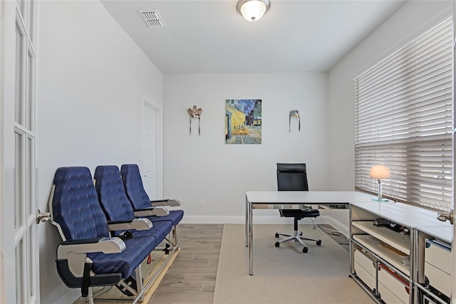 office area with baseboards, visible vents, and wood finished floors