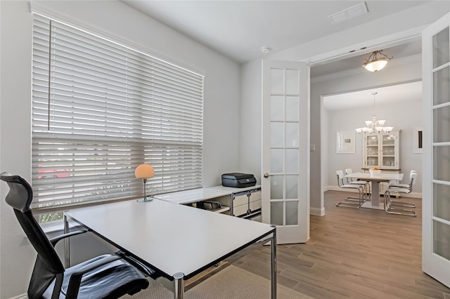 office space featuring french doors, visible vents, an inviting chandelier, and wood finished floors