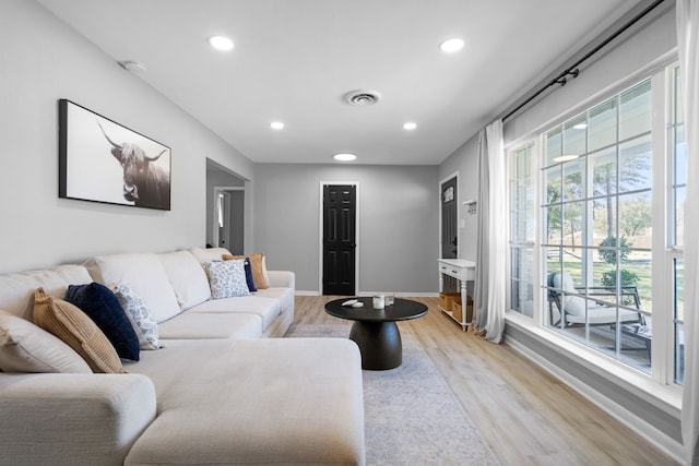 living room with recessed lighting, baseboards, visible vents, and light wood finished floors