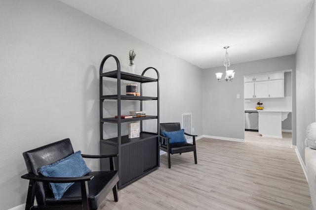 living area with light wood-style flooring, visible vents, a chandelier, and baseboards