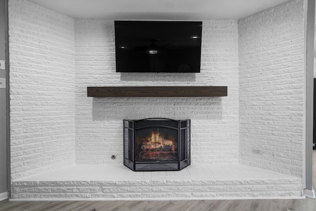 room details with a brick fireplace and wood finished floors