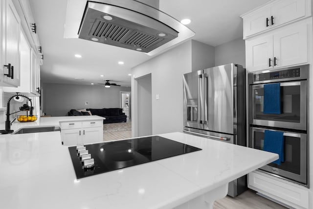 kitchen with white cabinets, open floor plan, ventilation hood, stainless steel appliances, and a sink