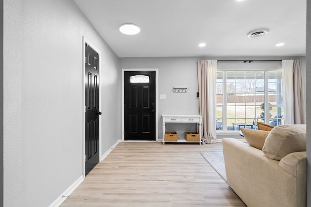 foyer with light wood finished floors, baseboards, visible vents, and recessed lighting