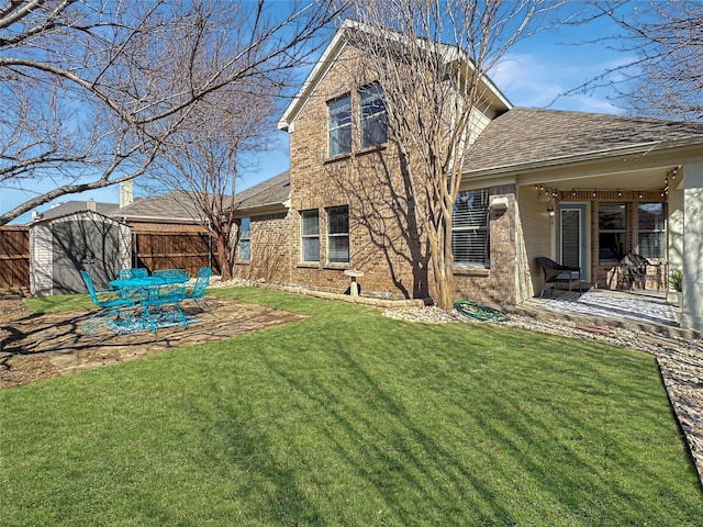 back of house with brick siding, a yard, a storage shed, a patio area, and an outdoor structure