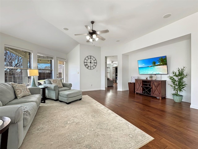 living room featuring ceiling fan, vaulted ceiling, wood finished floors, and baseboards