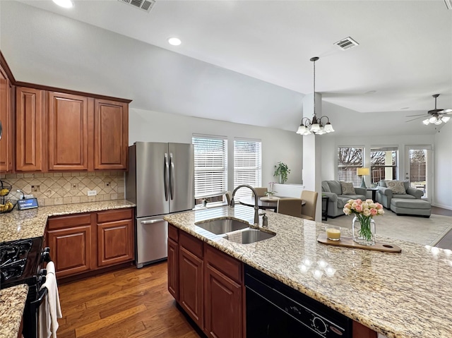 kitchen featuring a sink, visible vents, vaulted ceiling, freestanding refrigerator, and gas stove