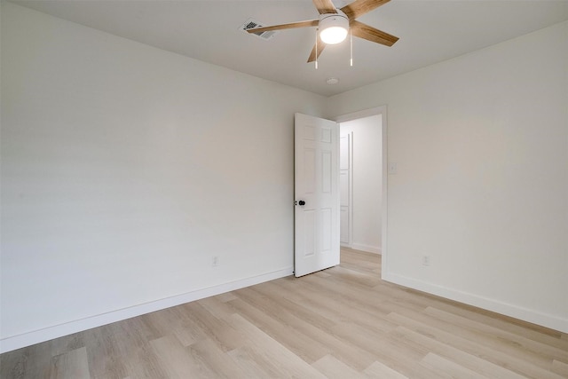 spare room with light wood-type flooring, a ceiling fan, and baseboards