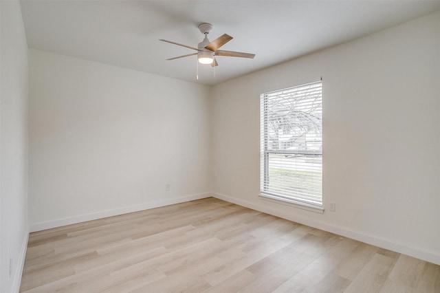 unfurnished room with ceiling fan, light wood finished floors, and baseboards