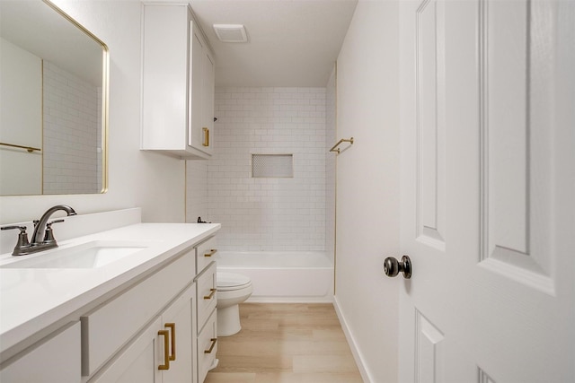 bathroom featuring toilet, wood finished floors, vanity, visible vents, and baseboards