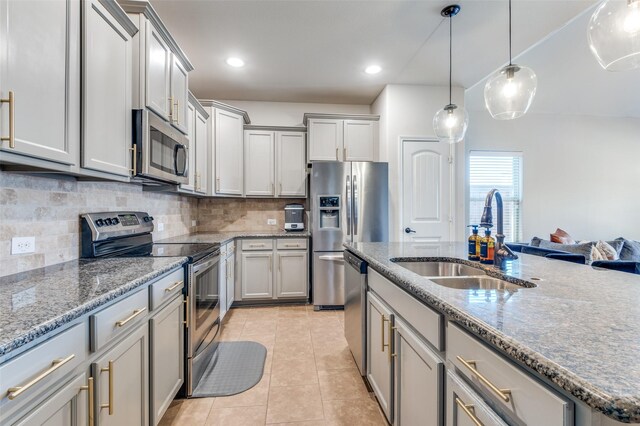 kitchen featuring ceiling fan, stainless steel appliances, stone countertops, and a sink