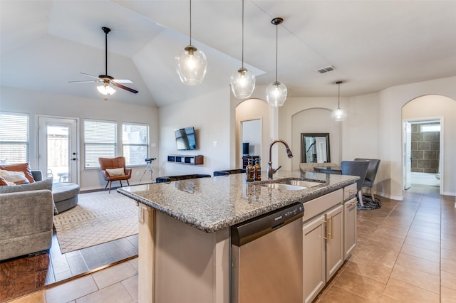 kitchen featuring visible vents, a sink, stainless steel dishwasher, open floor plan, and arched walkways