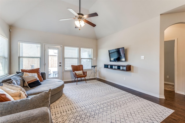 living room with baseboards, wood finished floors, arched walkways, high vaulted ceiling, and a ceiling fan