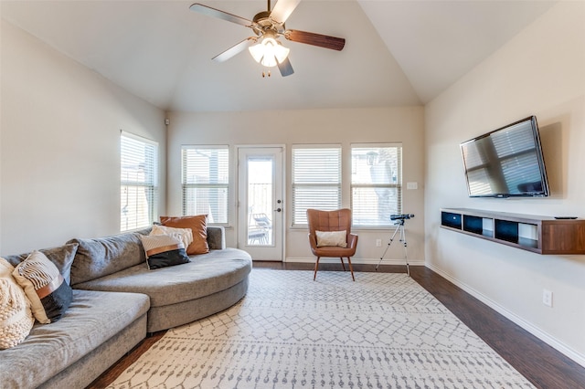 living room with baseboards, dark wood finished floors, a ceiling fan, and vaulted ceiling