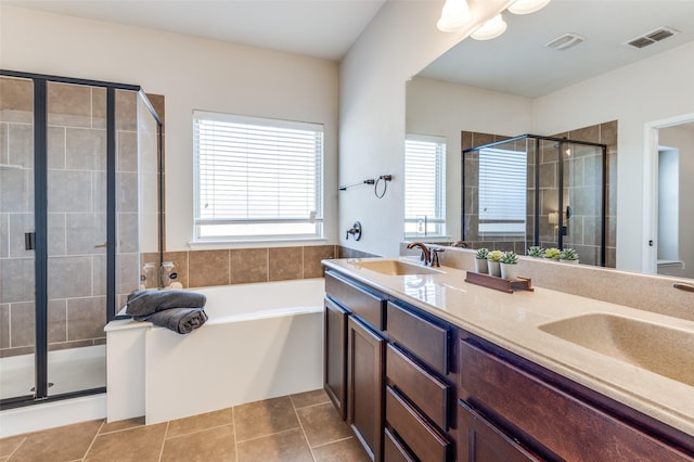 bathroom with tile patterned flooring, visible vents, a shower stall, and a sink