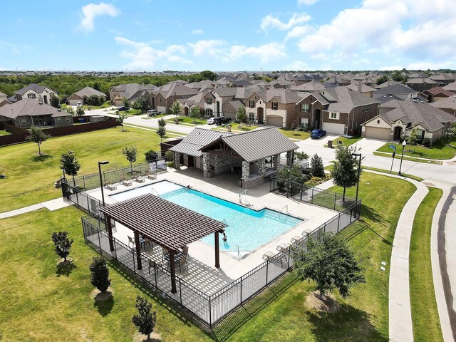 pool featuring a residential view, a yard, and fence