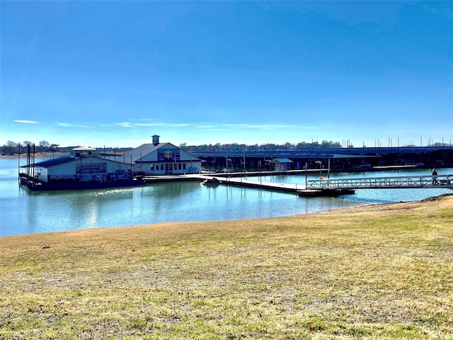 dock area with a yard and a water view