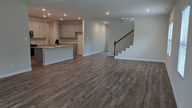 kitchen with stainless steel appliances, dark wood-type flooring, and open floor plan