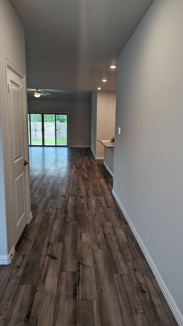 hall with dark wood-style floors and baseboards