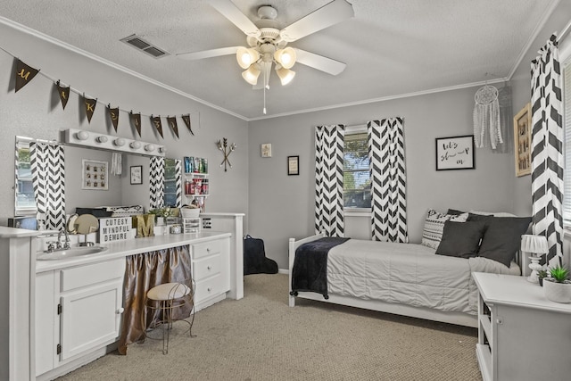 bedroom with a textured ceiling, light carpet, a sink, visible vents, and crown molding