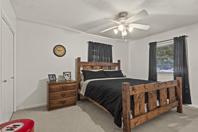 carpeted bedroom with crown molding, baseboards, ceiling fan, and a textured ceiling