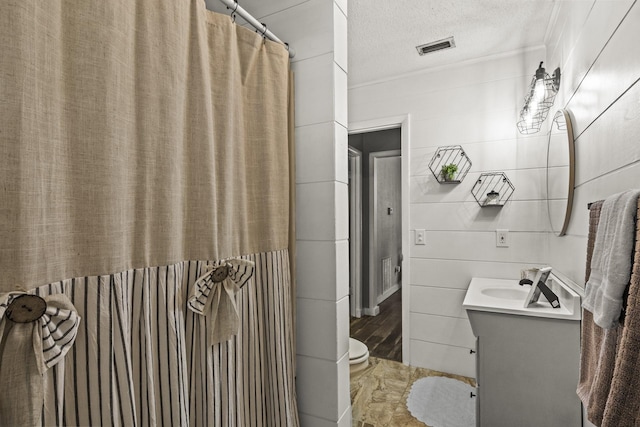 bathroom with visible vents, a textured ceiling, and vanity