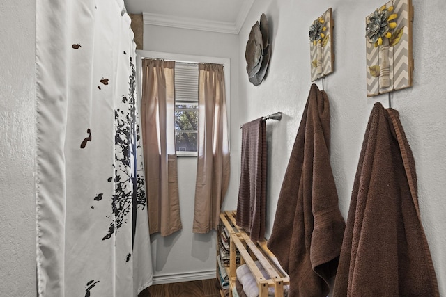 bathroom with crown molding and wood finished floors