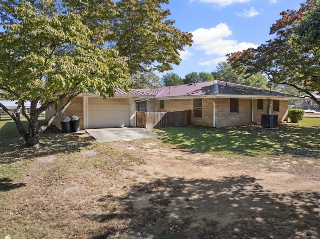 view of front of property featuring brick siding, an attached garage, metal roof, fence, and driveway