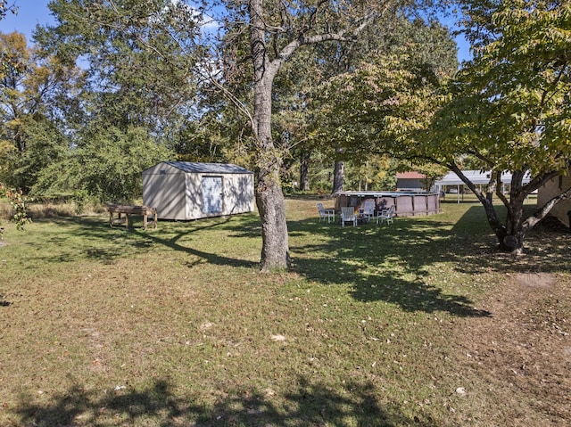 view of yard with a storage unit, an outdoor structure, and an outdoor pool