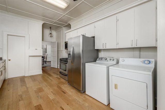 washroom with laundry area, washing machine and dryer, and light wood-style flooring