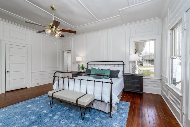 bedroom with a ceiling fan, wood-type flooring, and a decorative wall