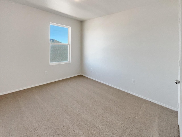 carpeted empty room with baseboards