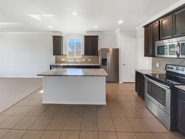 kitchen with dark brown cabinetry, light tile patterned floors, appliances with stainless steel finishes, and ornamental molding