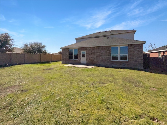 rear view of house with a patio area, a fenced backyard, and a lawn