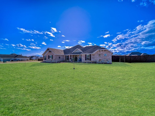 exterior space featuring a front lawn, fence, and brick siding