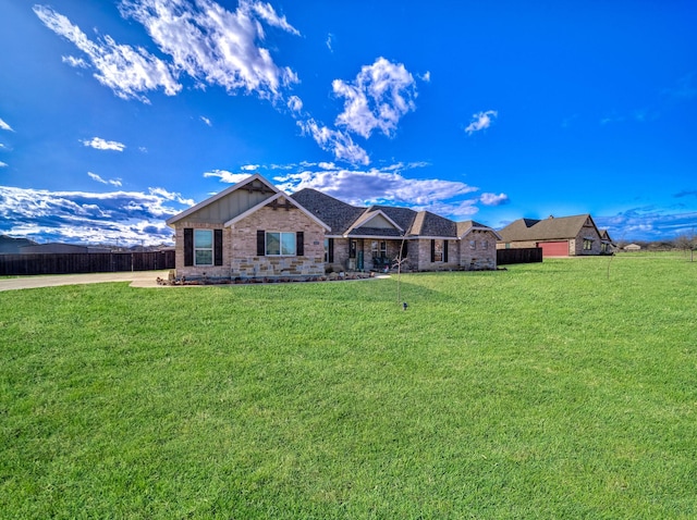 view of front of home with a front yard, brick siding, and fence