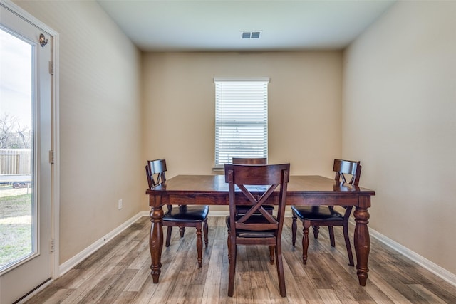 dining area featuring light wood-type flooring, visible vents, and baseboards