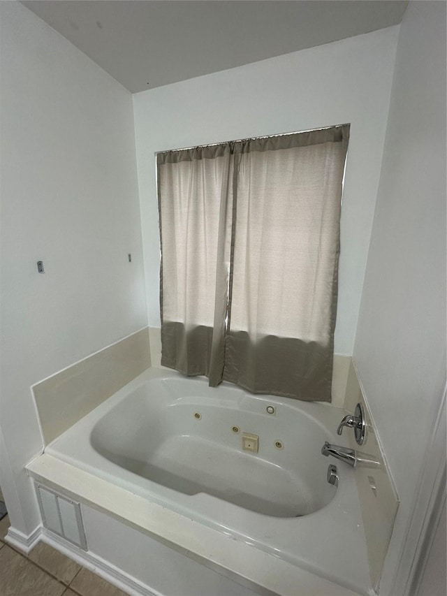 bathroom with a whirlpool tub and tile patterned flooring