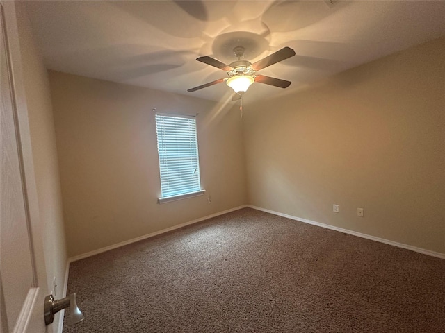 carpeted spare room featuring ceiling fan and baseboards