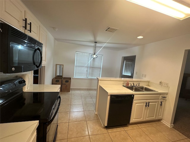 kitchen featuring visible vents, black appliances, light countertops, and a sink