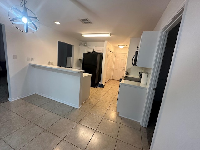 kitchen with light tile patterned floors, visible vents, a peninsula, black appliances, and white cabinetry