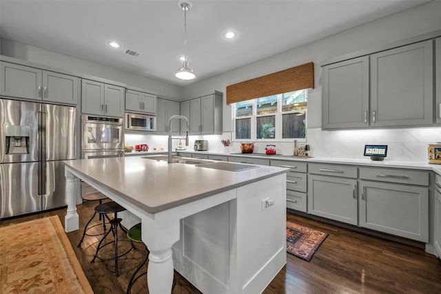 kitchen with stainless steel appliances, gray cabinets, visible vents, backsplash, and a sink