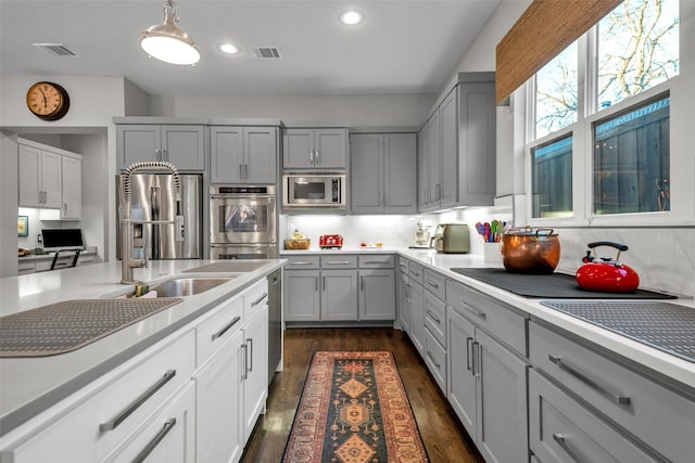 kitchen featuring visible vents, light countertops, appliances with stainless steel finishes, gray cabinets, and dark wood-style floors