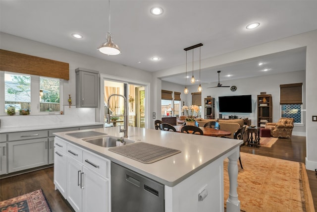 kitchen featuring a sink, dark wood-type flooring, dishwasher, and light countertops