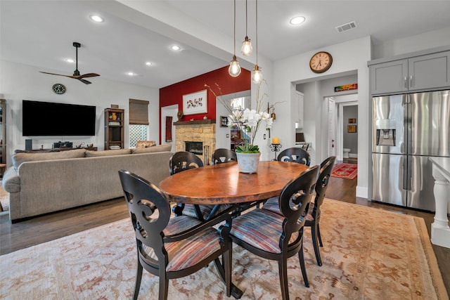 dining room with a fireplace, visible vents, wood finished floors, and recessed lighting